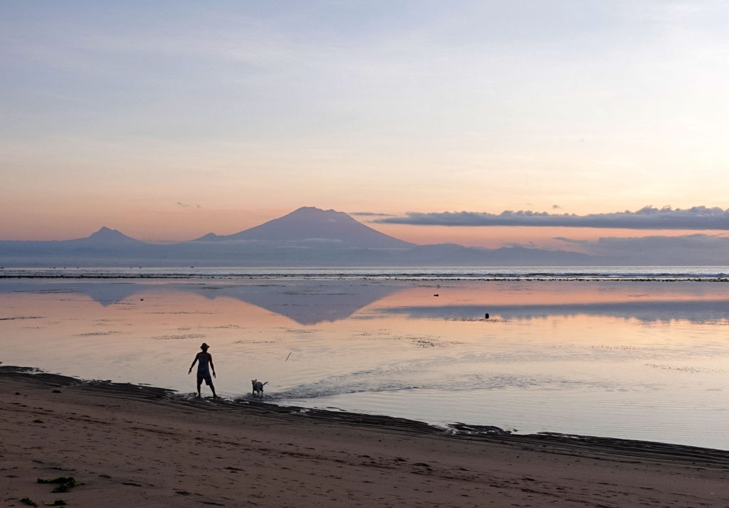 local people and silhouette of agung mountain on balinese island