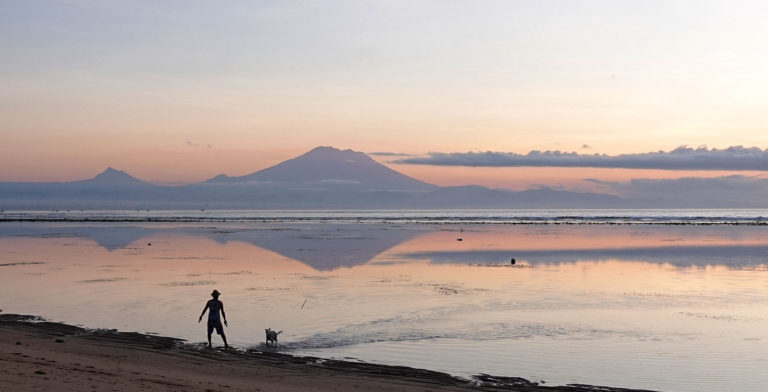 Local People And Silhouette Of Agung Mountain On Balinese Island