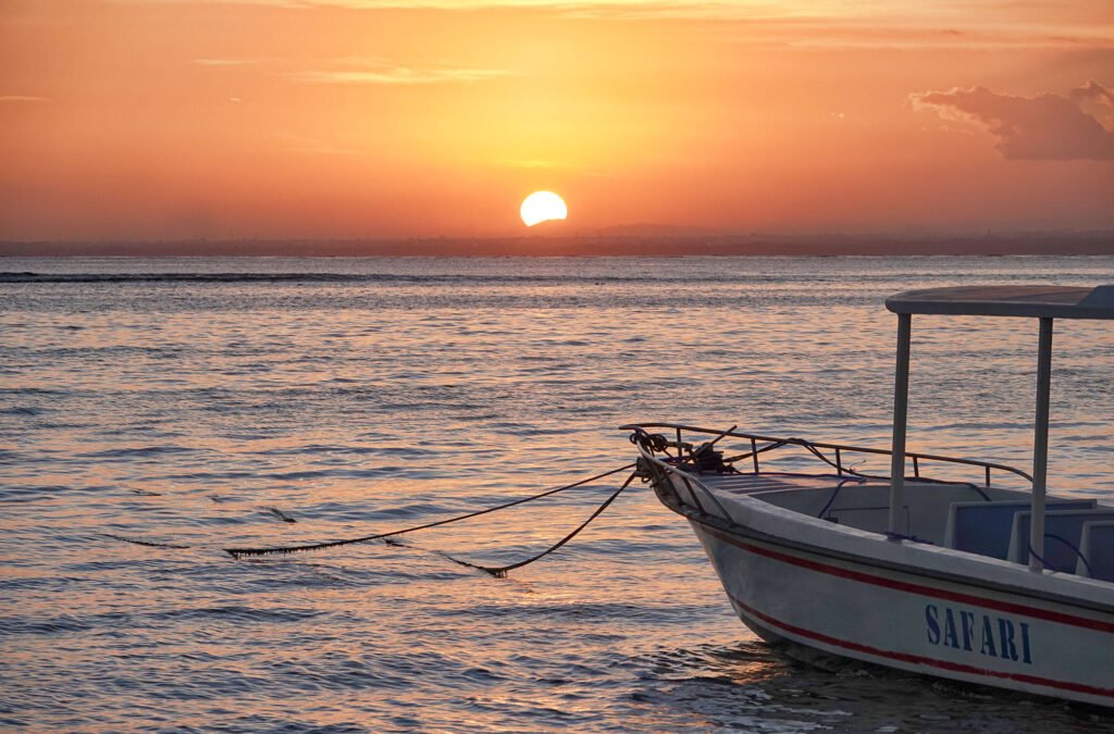 sunset and traditional boat on jungut batu beach
