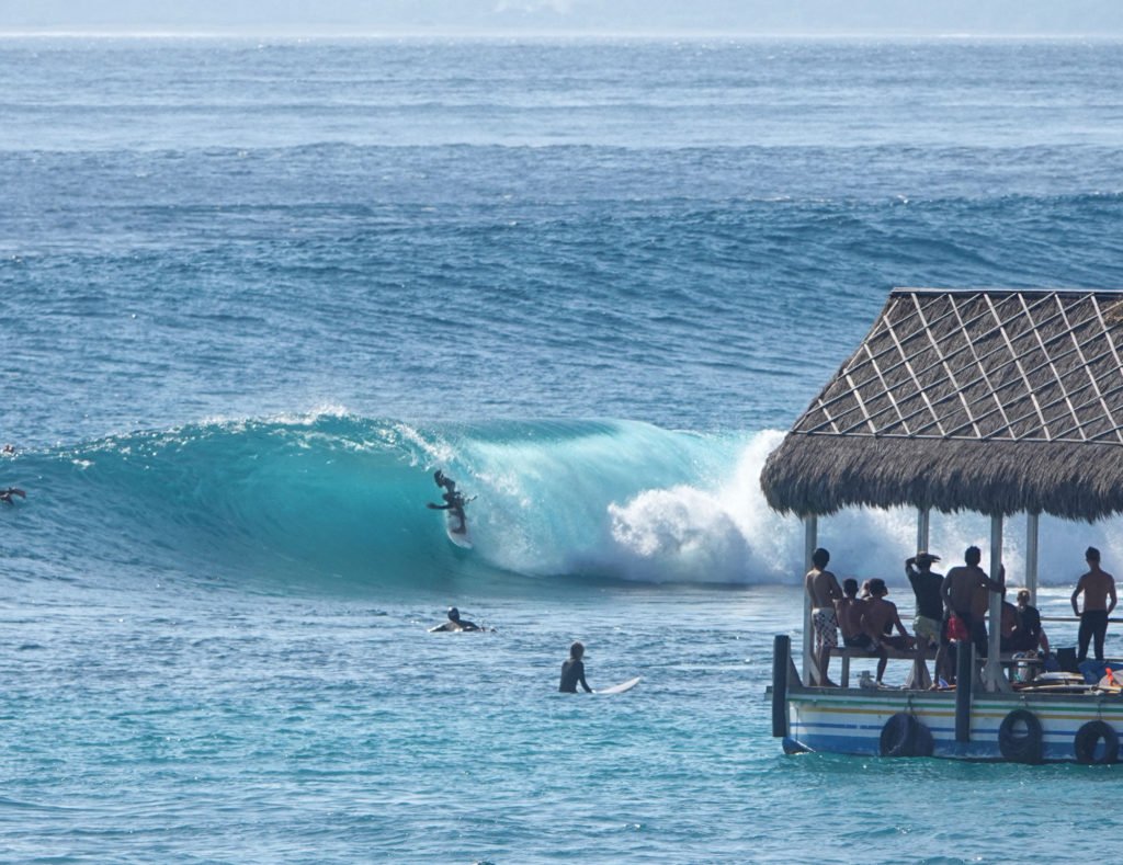 Onlookers watch skilled surfers from the safety of a pontoon at Lacerations surf break.