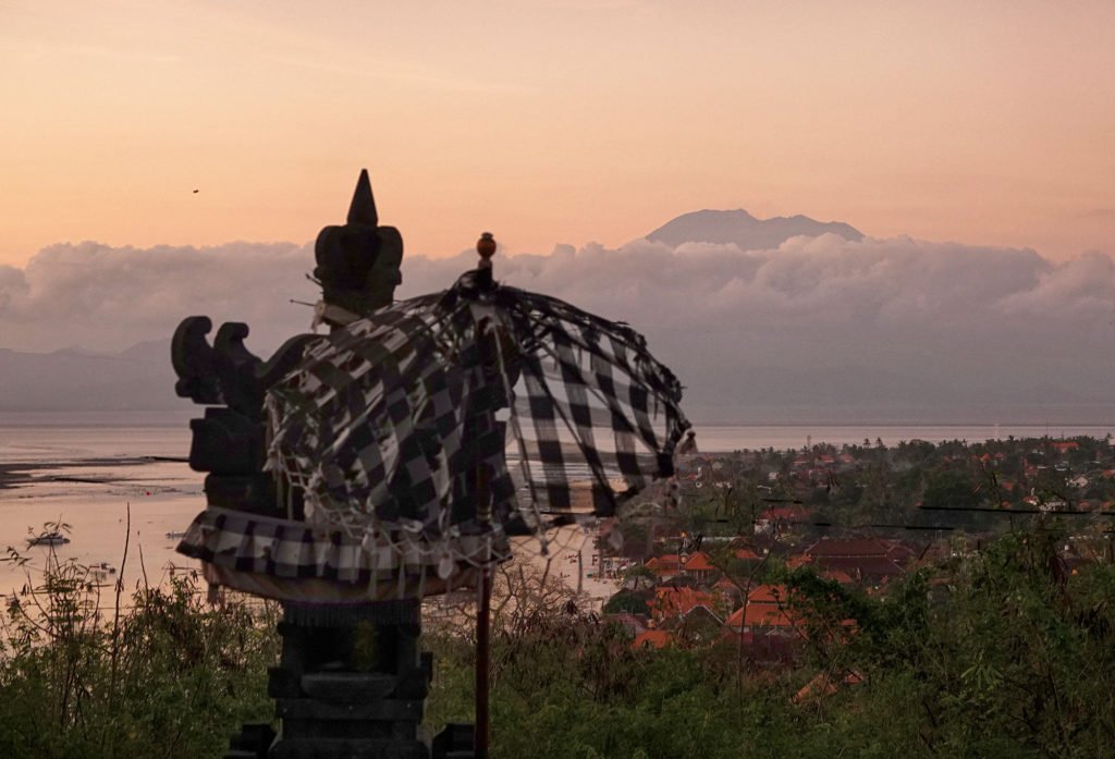 An incredible sunset over Jungutbatu village, illuminating the top of Mount Agung in the distance; a spectacular view.