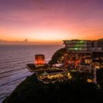 Savaya Bali in Uluwatu at sunset, the illuminated Cube stage and packed clifftop terraces above the Indian Ocean