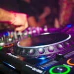 Close-up of a DJ mixing on a controller under warm lights, evoking the R&B and hip-hop night INNO at Da Maria in Seminyak, Bali.