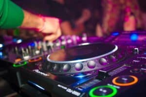 Close-up of a DJ mixing on a controller under warm lights, evoking the R&B and hip-hop night INNO at Da Maria in Seminyak, Bali.
