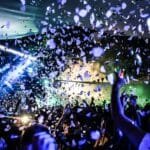 Crowd dancing under coloured lights at a nightclub, evoking the Afro-house energy of Junction Africa at The Mesa Bali in Berawa, Bali.