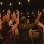 People dancing at an outdoor night party under warm string lights, evoking the Afro and amapiano vibe of Ulu Riddim at Hatch Uluwatu, Bali.