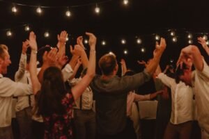 People dancing at an outdoor night party under warm string lights, evoking the Afro and amapiano vibe of Ulu Riddim at Hatch Uluwatu, Bali.